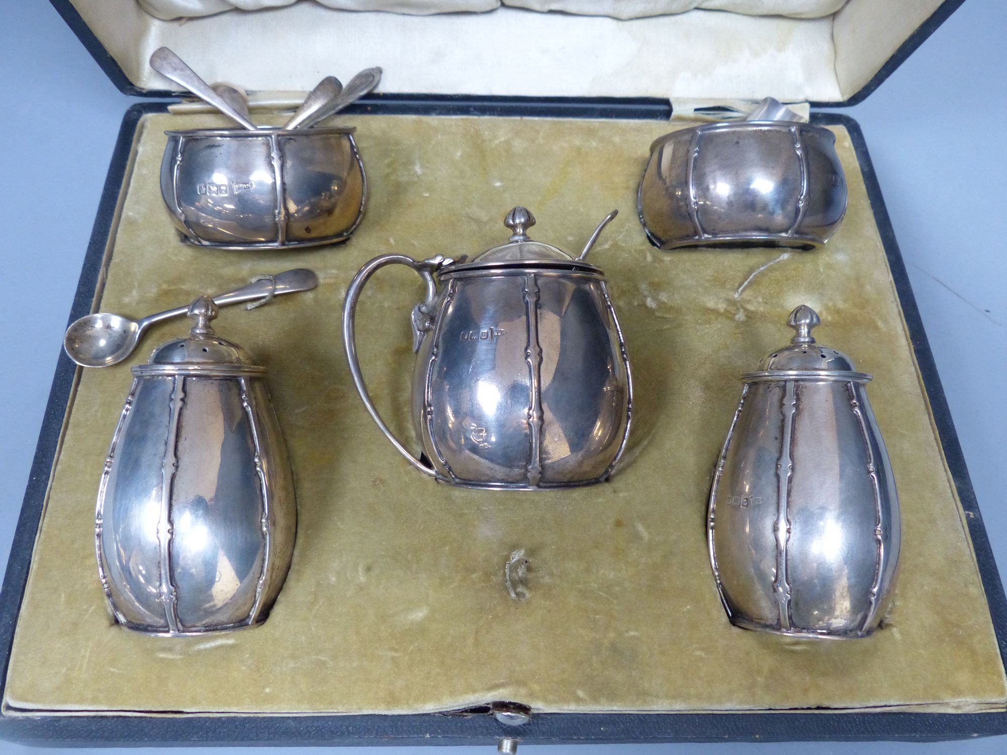 A cased George V silver five piece condiment set with two matching spoons, Walker & Hall, Sheffield, 1913,